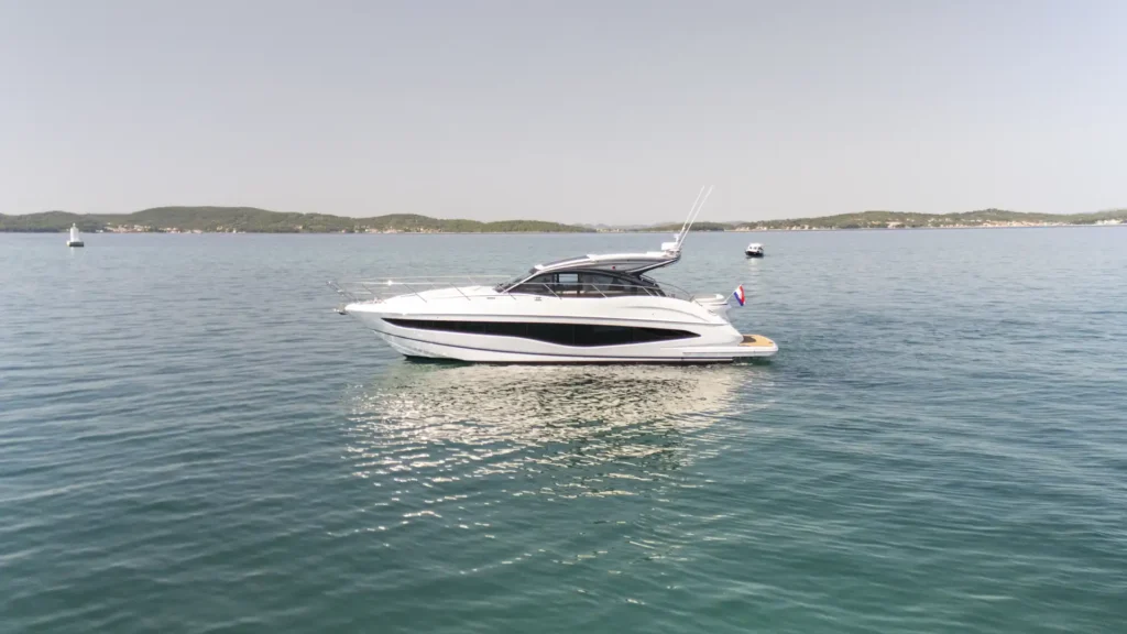 Seitenansicht der Princess V50 – Decksalon beim Fahren auf offenem Wasser, mit Fokus auf das aerodynamische Design und die großzügige Deckfläche.
