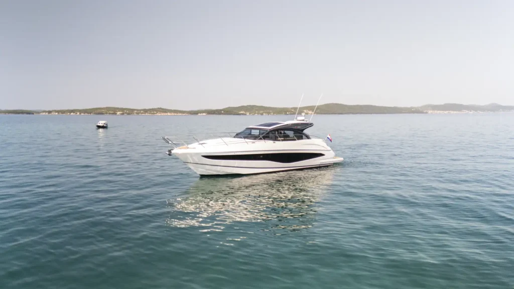 Backbordansicht der Princess V50 – Decksalon Yacht, die getönten Panoramafenster und die schlanke Rumpfform hervorhebend.