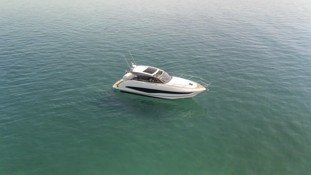 Drohnenaufnahme der Princess V50 – Decksalon über türkisfarbenem Wasser, die gesamte Yacht und ihr Sonnendach sind klar erkennbar.