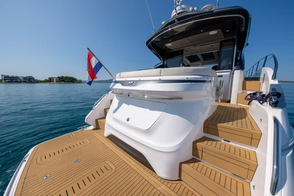 Detailaufnahme der Badeplattform und der hinteren Treppe der Princess V50 – Decksalon mit kroatischer Flagge im Wind.