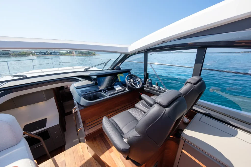 Moderner Fahrstand der Princess V50 – Decksalon mit zwei luxuriösen Steuersitzen, Holzverkleidung und großem Panoramablick.