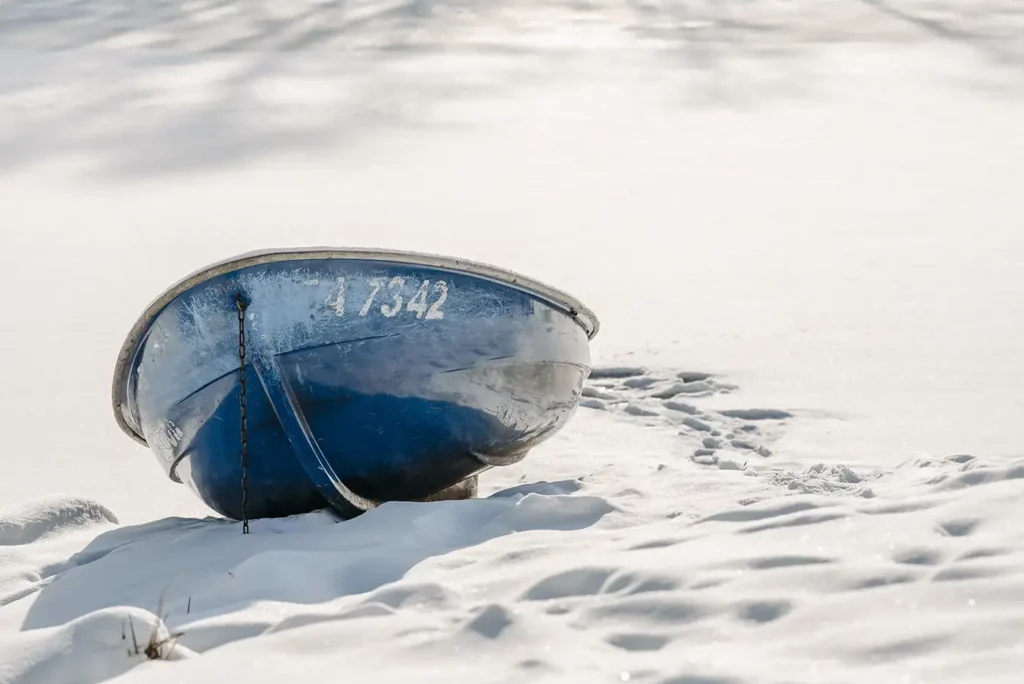 Winterkauf: Ein Ruderboot am Ufer im Schnee