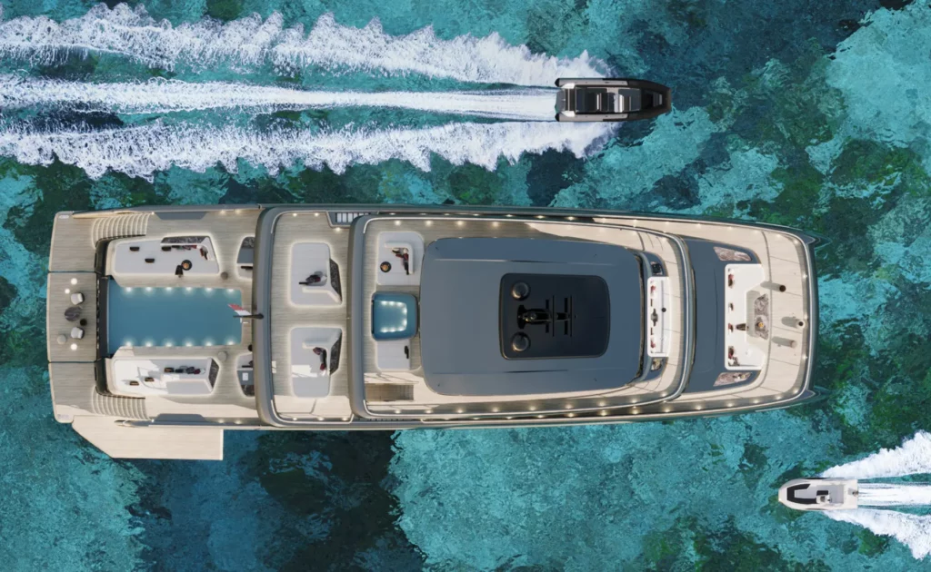 Luftaufnahme des 50M Sunreef Explorer, die das gesamte Schiff zeigt, während es über kristallklares, türkisfarbenes Wasser gleitet. Die geräumigen Deckflächen und die beeindruckende Größe der Yacht sind deutlich zu erkennen.