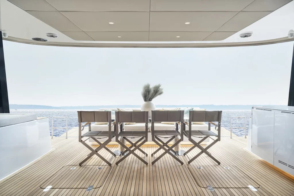 Geräumiger Außen-Essbereich auf der Sunreef 60, mit einem Tisch, der für Mahlzeiten gedeckt ist, und einem atemberaubenden Blick auf das Meer.