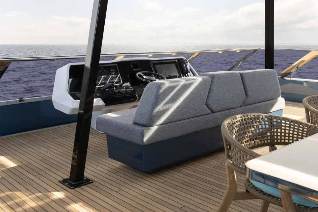 Der Steuerstand auf der Flybridge der Sunreef Power 60P Eco Yacht, mit modernen Instrumenten und einem Sitzbereich, der einen weiten Blick auf das Meer ermöglicht.