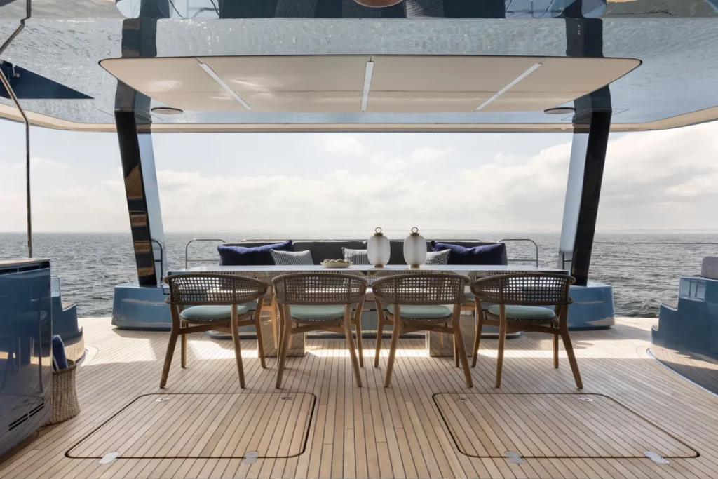 Ein eleganter Außenessbereich auf der Sunreef Power 60P Eco Yacht, der direkten Blick auf das Meer bietet. Der Bereich ist mit stilvollen Möbeln ausgestattet und lädt zum Entspannen ein, während die Yacht umweltfreundlich durch das Wasser gleitet.
