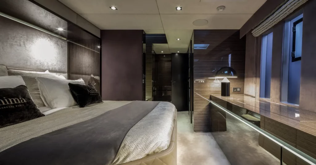 Stilvoll eingerichtetes Schlafzimmer auf der Sunreef 70 Yacht mit einem großen Bett, luxuriösen Textilien und einer modernen Innenausstattung in warmen Tönen.