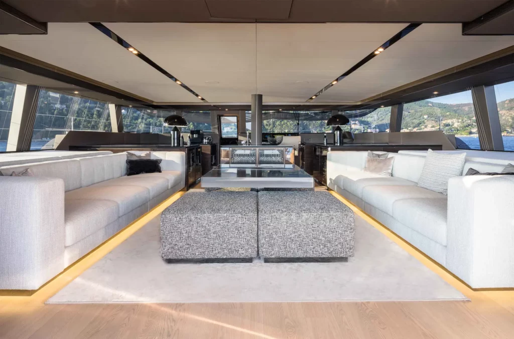 Luxuriöser Innenraum der Sunreef 70 Yacht mit stilvollen, modernen Sofas und einem eleganten Wohnbereich, der durch große Fensterpanoramen viel Tageslicht erhält.