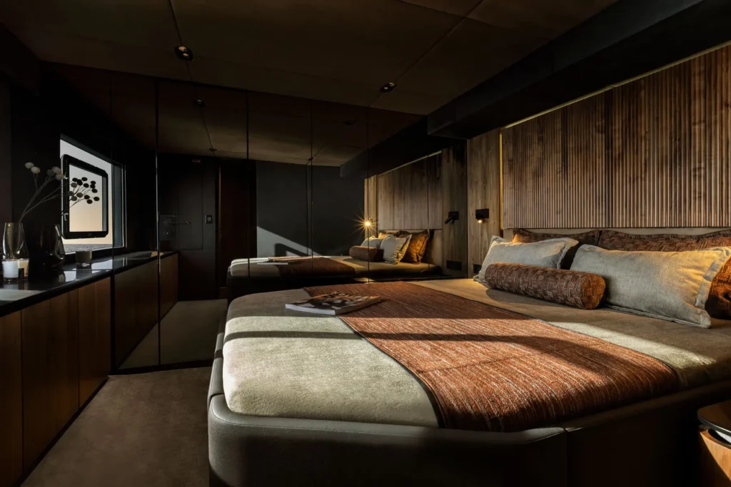 Elegantes Schlafzimmer des 70 Sunreef Power, mit einem großen Doppelbett und luxuriöser Ausstattung, beleuchtet durch sanftes Umgebungslicht.