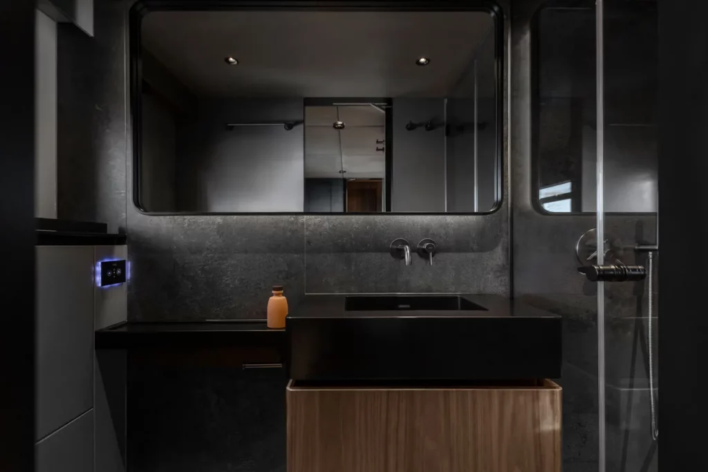 Modernes Badezimmer im 70 Sunreef Power, mit eleganten, dunklen Oberflächen und minimalistischer Einrichtung.