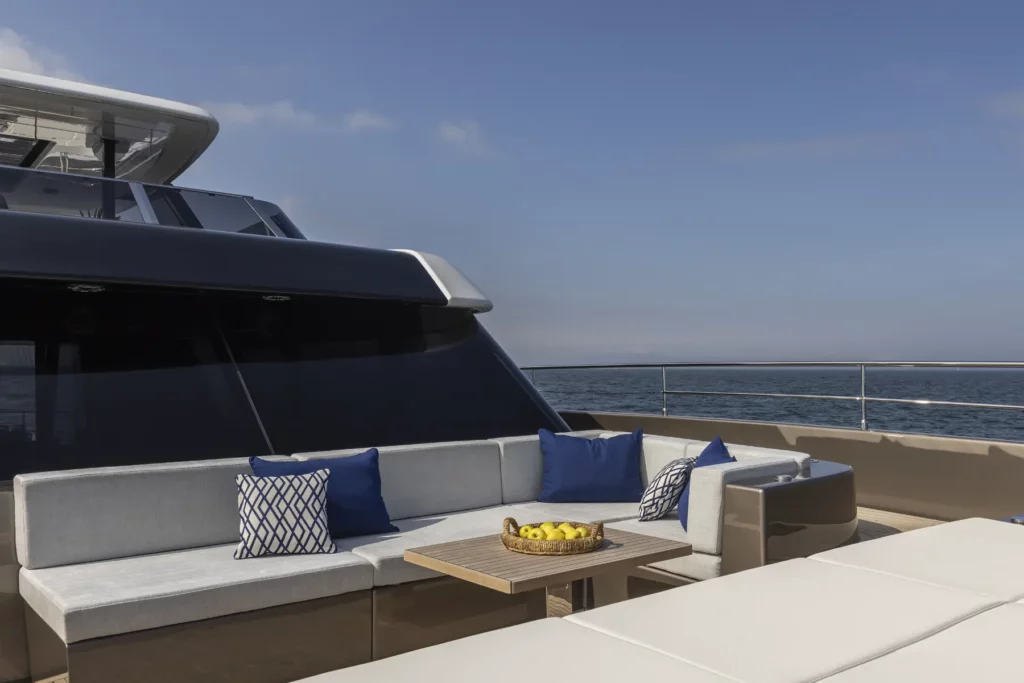 Eine luxuriöse Bugterrasse auf der 80 Sunreef Power, ausgestattet mit bequemen Sitzgelegenheiten und Kissen in Blau und Weiß, perfekt für entspannte Momente auf dem Meer.