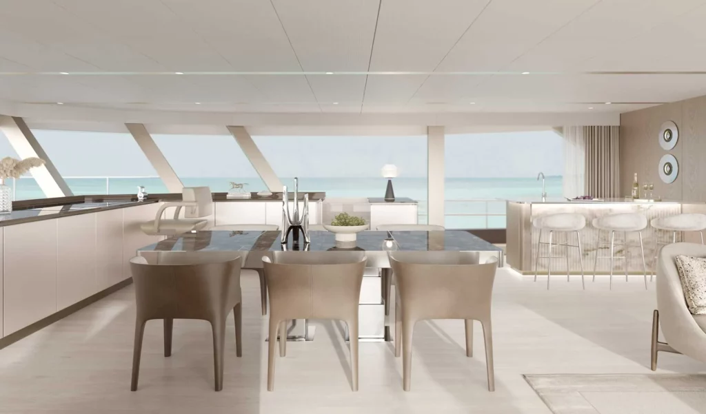 Essbereich im Inneren eines Sunreef Supreme Power Eco-Katamarans, ausgestattet mit einem großen Esstisch, modernen Stühlen und einer Bar, umgeben von Panoramafenstern mit Blick auf das Meer.