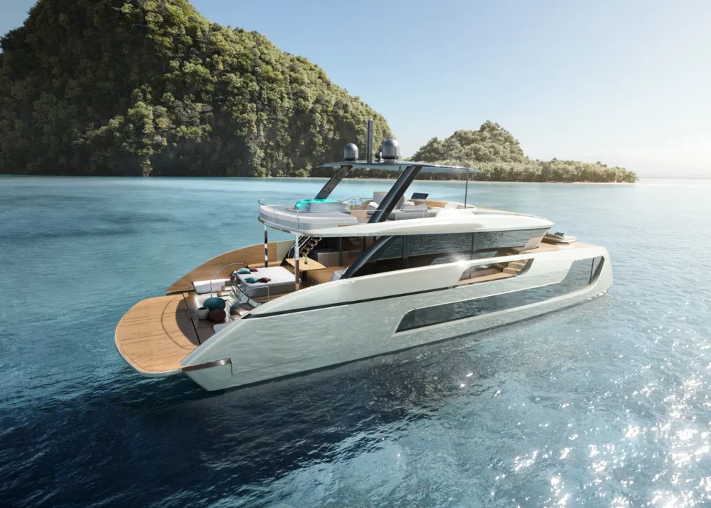 Ansicht von oben der Sunreef Ultima 77, die in der Nähe einer felsigen Küste ankert. Die Yacht bietet viel Platz für Sonnenliegen und Freizeitaktivitäten auf dem Heckdeck.