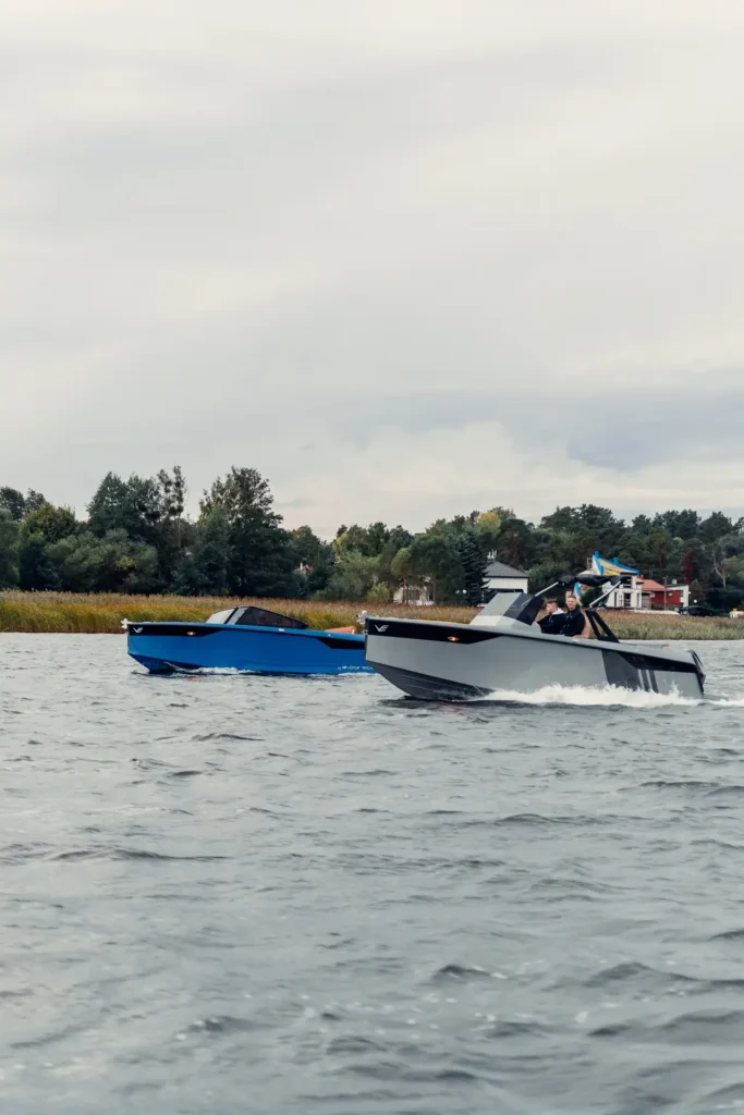 Luxury Veloce Yachts V755 motorboat gliding on the water, featuring a bold red hull, open cockpit layout, and contemporary Italian styling under clear skies.