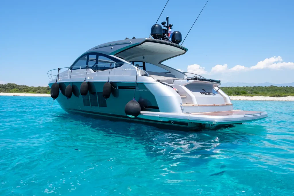 Dynamische Heckansicht der Fairline Targa 48 Open mit glänzender Oberfläche auf offenem Meer.