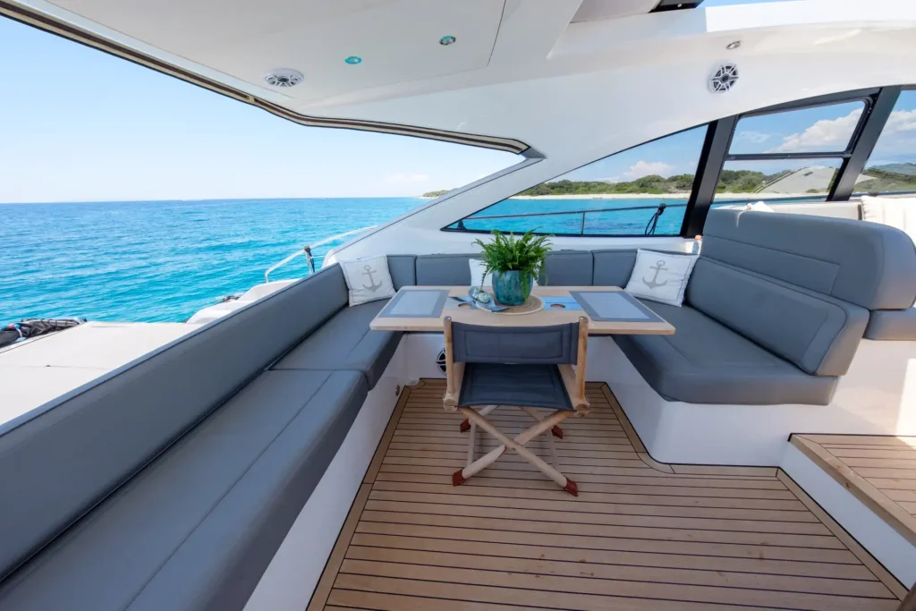 Gemütlicher Loungebereich der Fairline Targa 48 Open mit grauen Polstern und Meerblick.