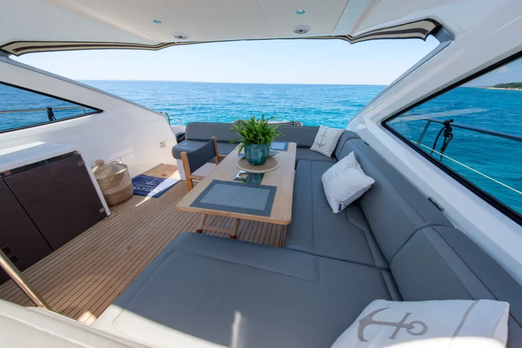 Seitlicher Blick auf den Essbereich im Freien der Fairline Targa 48 Open mit Meer im Hintergrund.