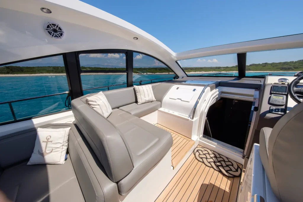 Eleganter Innenbereich der Fairline Targa 48 Open mit grauen Sitzflächen, Tisch und Meerblick.