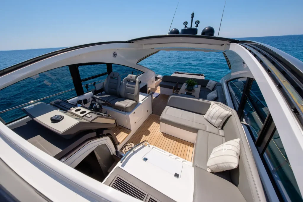 Sitzbereich und Zugang zum unteren Deck der Fairline Targa 48 Open mit Blick auf das Cockpit.