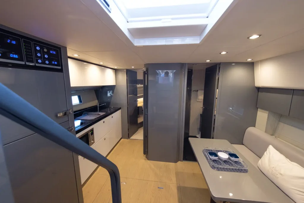 Blick in den eleganten Innenraum der Fairline Targa 48 Open mit Küche, Salon und Zugang zu Kabinen und Bad.
