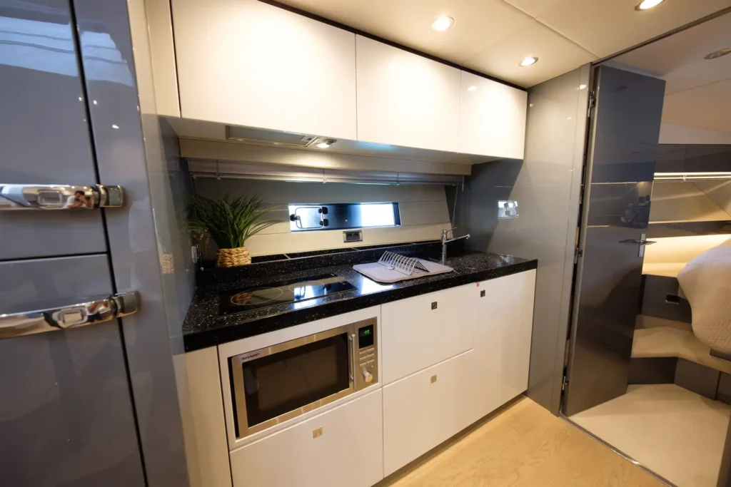 Voll ausgestattete Küche an Bord der Fairline Targa 48 Open, inklusive Herd, Spüle und Mikrowelle.