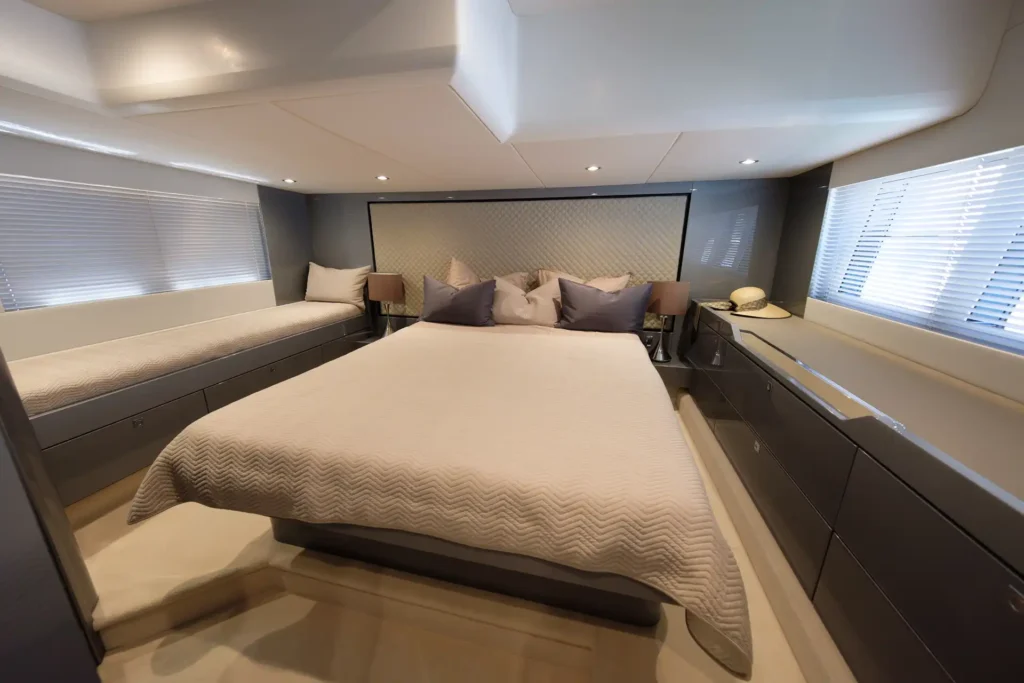 Großzügige Hauptkabine mit Doppelbett, Einzelbett, eleganter Einrichtung und seitlichen Fenstern in der Fairline Targa 48 Open.