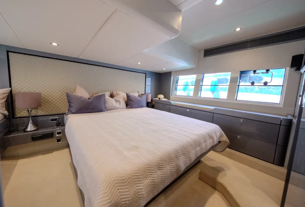 Blick von der Hauptkabine auf Doppelbett und großes Fenster in der Fairline Targa 48 Open.