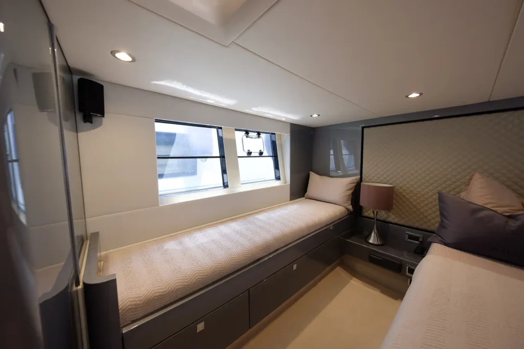 Komfortables seitliches Einzelbett mit Fensterblick in der Hauptkabine der Fairline Targa 48 Open.