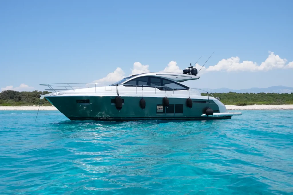 Seitenansicht der Fairline Targa 48 Open, die vor Anker liegt, umgeben von klarem Wasser.