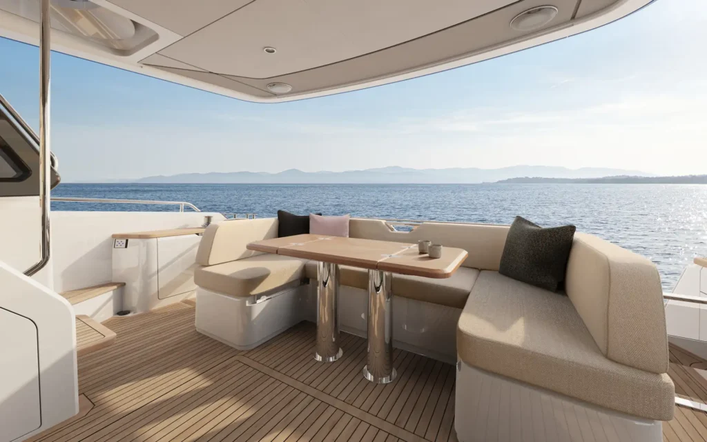 Afterdeck der Princess F54 mit gemütlichen Sitzbänken und Esstisch mit Blick auf das Meer.