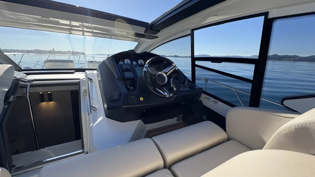 Innenansicht der Cranchi M44 Richtung Heck mit Sitzbank und Blick auf Wasser und leichte Heckwelle.