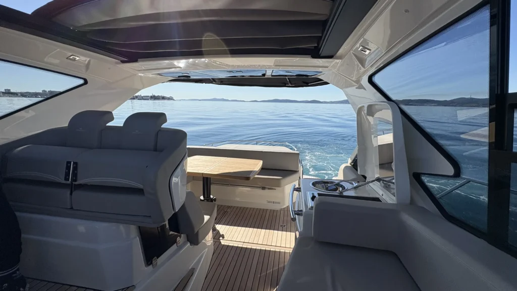 Innenansicht der Cranchi M44 Richtung Heck mit Sitzbank und Blick auf Wasser und leichte Heckwelle.