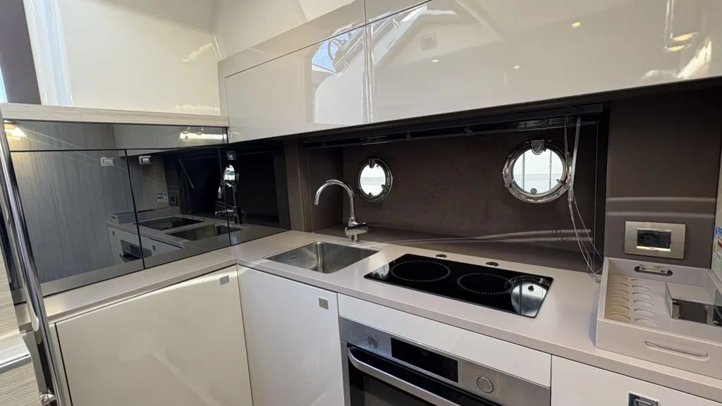 Gästekabine der Cranchi M44 mit zwei Einzelbetten und Leselampen, helles Holzdekor und Spiegelwand.